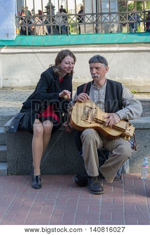 Kiev Ukraine - May 1 2016: Girl with a street musician playing instrument nastarinom - ogranistrume