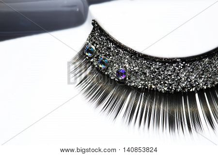 Black false eyelash with rhinestone on white background