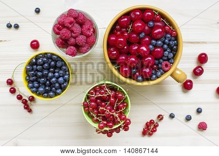Fresh summer meal background: mix berries on a wooden table top view.