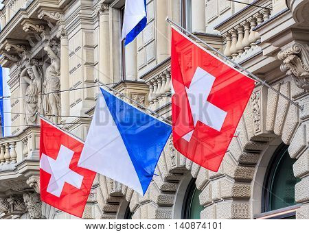 Zurich, Switzerland - 30 July, 2016: facade of the Credit Suisse building on Paradeplatz square decorated with flags of Switzerland and Zurich. Credit Suisse Group is a Swiss multinational financial services holding company headquartered in Zurich.