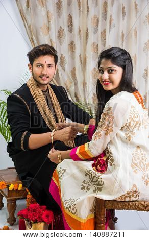 Indian young sister tying rakhi on brother's wrist, a tradition on Raksha Bandhan festival