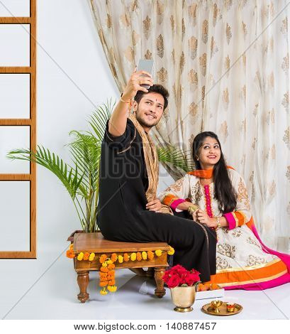 Indian brother taking selfie with sister on Raksha Bandhan festival after tying knot or rakhi