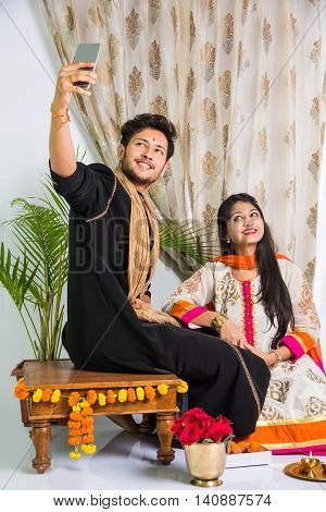 Indian brother taking selfie with sister on Raksha Bandhan festival after tying knot or rakhi
