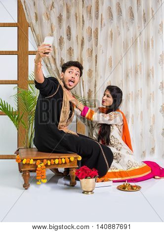 Indian brother taking selfie with sister on Raksha Bandhan festival after tying knot or rakhi