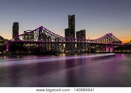 BRISBANE, AUSTRALIA: Story Bridge and cityscape by sunset, with CityCat ferry light trails on the river - magenta lights