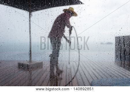 Blurred People Washing Decking By Pressure Wash. Focus On Water Drop