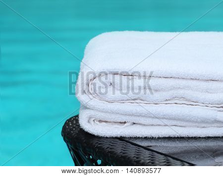 clean white white towel poolside on black table