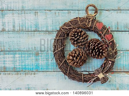 Twig wreath with paper hearts vintage furniture and fircones on old wood. Valentines day christmas background. Text space