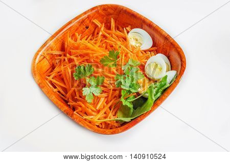 salad from carrot and quail eggs n a wooden bowl