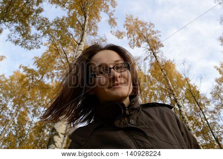 Beautiful woman enjoy autumn streaming her hairs. Woman is walking in the park and enjoy weather