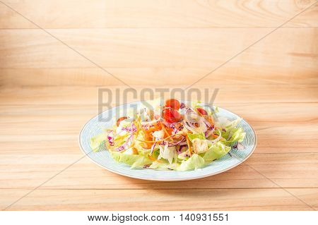 Salad vegetable food vegetarian in a plate placed on a wooden background.