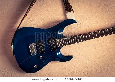 electric guitar on a background of vintage beige wall.