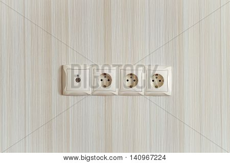 Electric socket strip with TV output. Interlocked electrical outlet on the wall.