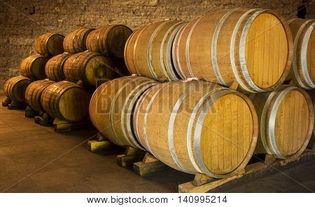Wine barrels stacked in the old cellar of the winery.