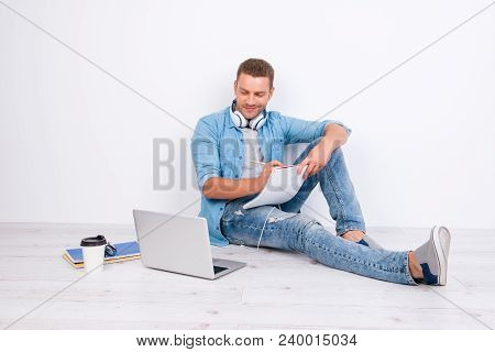 Process Of Studying. Preoccupied Attractive Guy Is Sitting On The Floor With Trendy Look,  Writing I