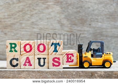 Toy Forklift Hold Letter Block E To Complete Word Root Cause On Wood Background