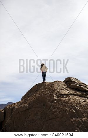 Young Woman At Ock Formations Of Dali Desert In Bolivia At Eduardo Avaroa Andean Fauna National Rese