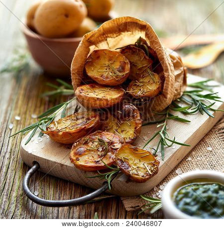 Baked Potatoes. Baked Halves Of Potatoes Seasoned With Rosemary And Sea Salt On A Wooden Rustic Tabl