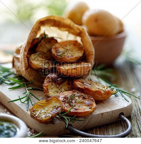 Baked Potatoes. Baked Halves Of Potatoes Seasoned With Rosemary And Sea Salt On A Wooden Rustic Tabl