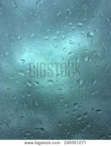 Raindrops On The Windshield With Shades Of Turquoise In The Background Outside