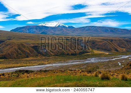 A Stream Meanders Quietly Through A Long Valley In New Zealand