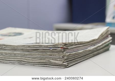 Closeup - Newspaper Stack On White Table In Office