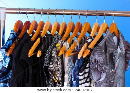 เสื้อผ้าต่าง ๆ บนไม้ hangers บนพื้นหลังสีน้ำเงิน