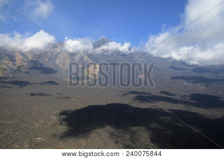 low clouds and dark shadows on Bove Valley, on background South-East Etna Volcanic Cone, Sicily