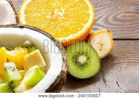 Dietary Juicy Fruit Salad Poured Into Half A Coconut With Slices Of Orange Kiwi And Banana