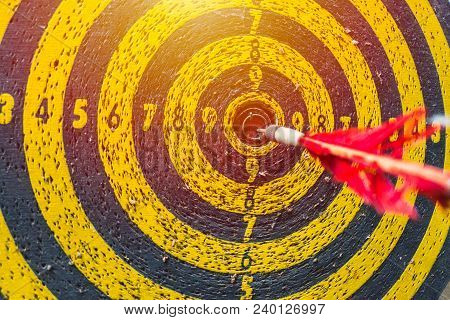 Hard To Win But Don't Stop To Try Concept: Old Dartboard With Arrow At Center After Many Times Attem