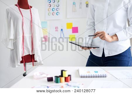 Stylish Fashion Designer Working With Measure Red Dummy As Sketches In Digital Tablet Of New Collect