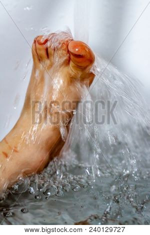 Little Girl Cleaning Her Dirty Feet In The Bathtub