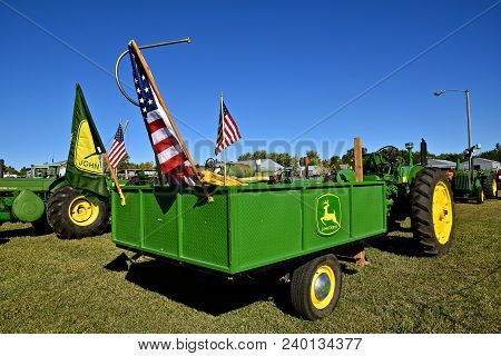 Dalton, Minnesota, Sept 8, 2017: A Restored John Deere Metal Trailer Or Wagon Bearing Patriotic Flag