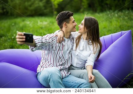 You Are My Soul. Young Couple Hugging And Kissing While Sitting On Inflatable Sofa Lamzac And Take S