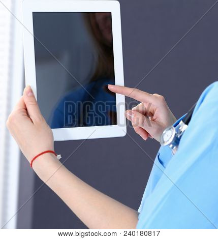 Woman Doctor Using Tablet Computer While Standing Straight In Hospital Office, Closeup. Healthcare, 
