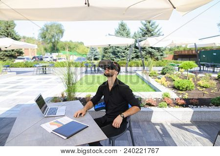 European Businessman Enjoying With Virtual Reality Glasses, Working With Laptop And Papers Under Bea
