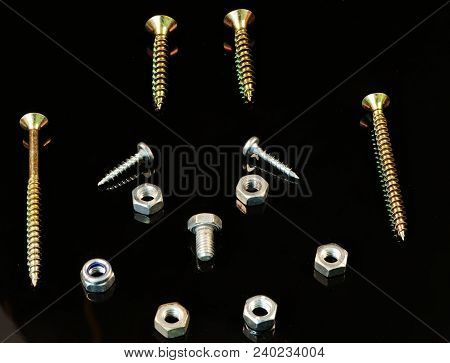 A Many Screws And Bolts In Arrangement As Face With Hairs, Eyes, Nose And Mouth On The Black Backgro