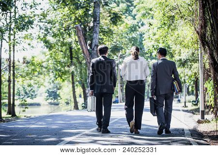 Businessman And Businesswoman Talking Outdoors About Their Business While Holding Document Report An