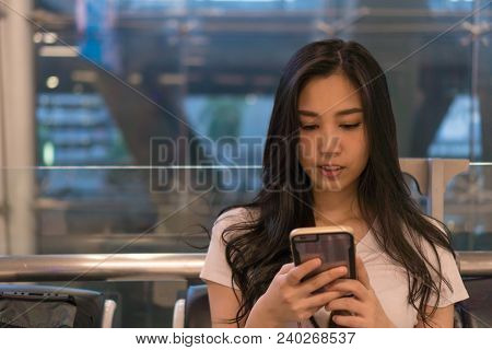 Tourist Girl Living Cell Phone At The Airport. She Is Waiting For A Trip. For Holiday Travel. Copy S