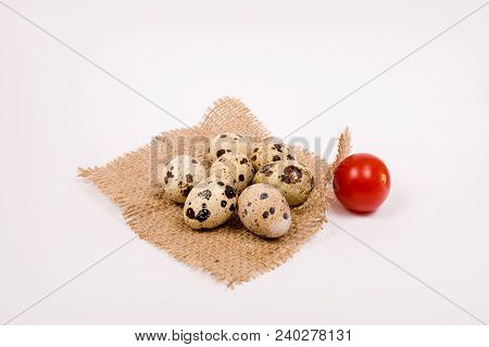 Quail Eggs And Tomato On Rustic Burlap Background. Spring Background With Small Easter Quail Eggs