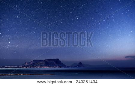 The Picturesque Landscape Of Misty Mountains And Sea. Vibrant Night Sky With Stars And Nebula And Ga