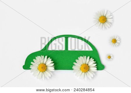 Paper Car Cut-out With Daisy Flowers On White Background - Eco-friendly Car Concept