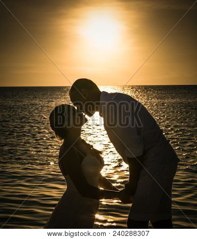 Olhuveli , Maldives-Jan 11, 2017: Silhouette of  Just marry couple have a kiss during Sunsett on Olhuveli island on Jan 11. 2017, Maldives.