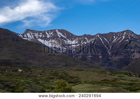 Beautiful Landscape Of Snow On The Mountains With A Clear Sky And Some Clouds