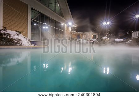 Hot Tubs And Ingound Heated Pool At A Mountain Village In Winter At Night
