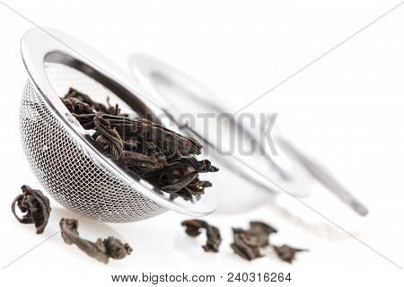 Black Tea, And Tea Strainer With Chain, Isolated On A White Background. A Black Tea And Tea Strainer