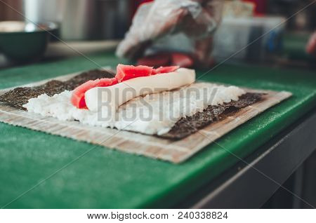 Professional Chef, Chef The Process Of Making Sushi Rolls, Spins Bamboo Mat And Cut Slices