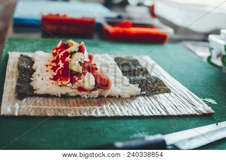 Professional Chef, Chef The Process Of Making Sushi Rolls, Spins Bamboo Mat And Cut Slices