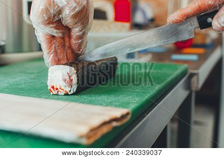 Professional Chef, Chef The Process Of Making Sushi Rolls, Spins Bamboo Mat And Cut Slices