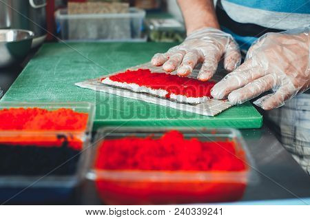 Professional Chef, Chef The Process Of Making Sushi Rolls, Spins Bamboo Mat And Cut Slices